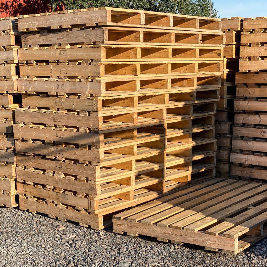 Stacked wooden shipping pallets outdoors.